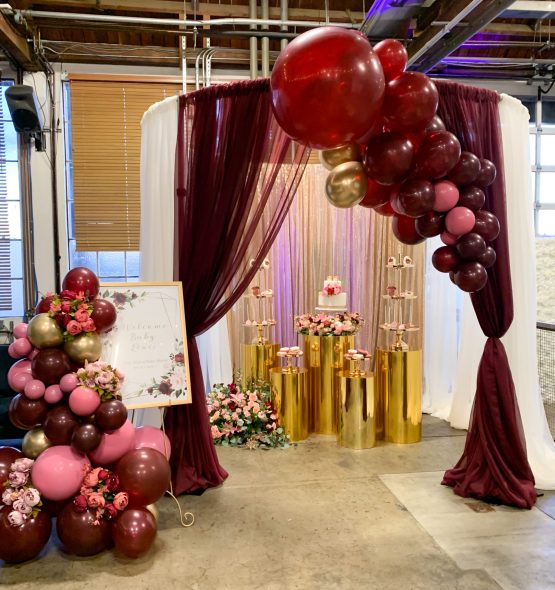 An elegant display of large canopy with Balloons over a cake and dessert display